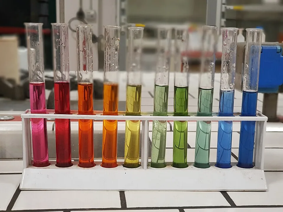 A row of test tubes containing different colors of pH indicator solution